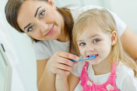 Mom and Daughter brushing their teeth - Pediatric Dentist in Memphis, TN